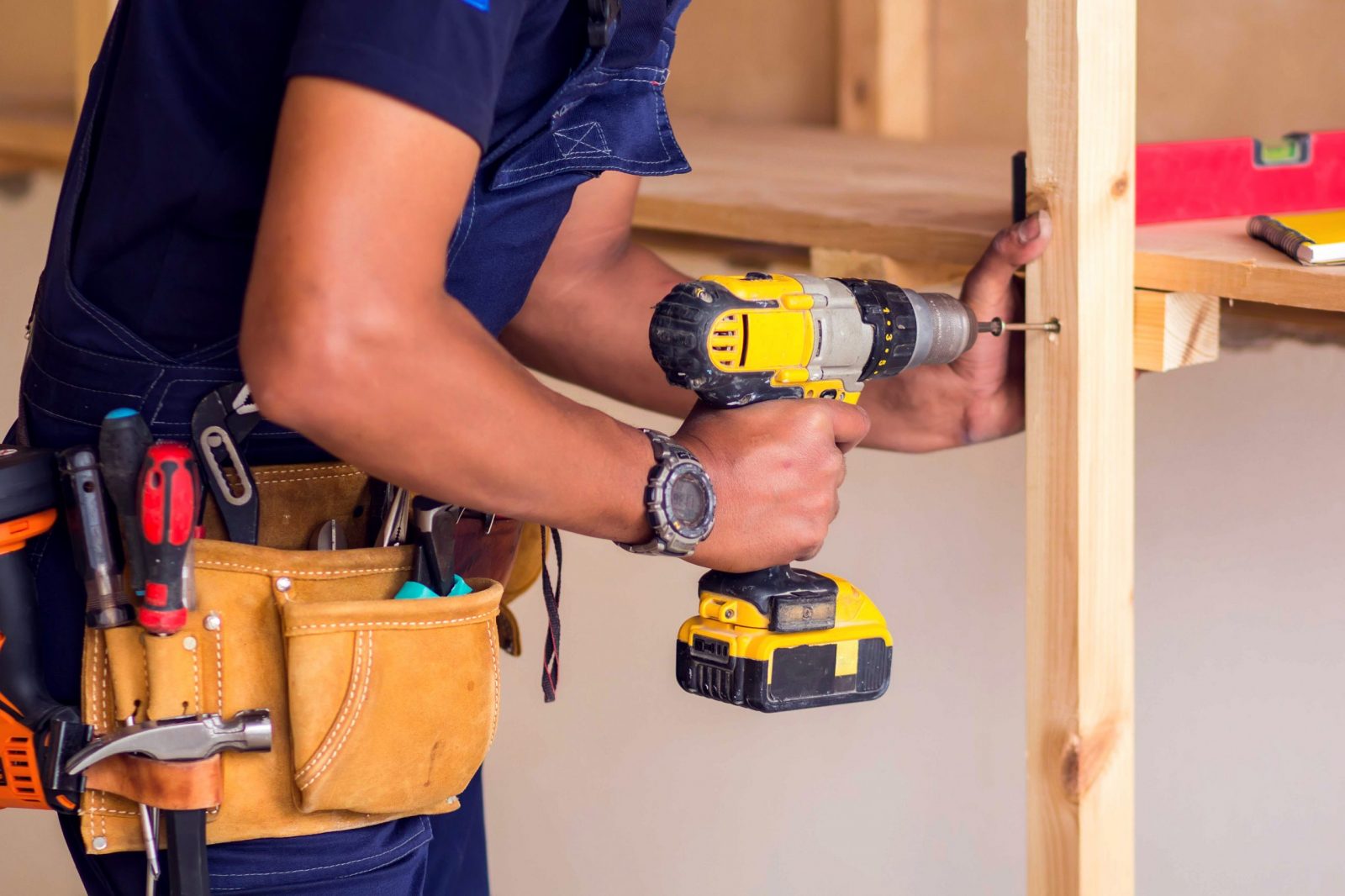 Handyman with headphones works with drill does repair. Joe Fix It carpentry work image