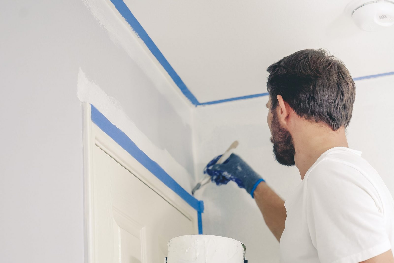 Close up of painter hands with gloves painting the wall edge by Joe Fix It Painting image